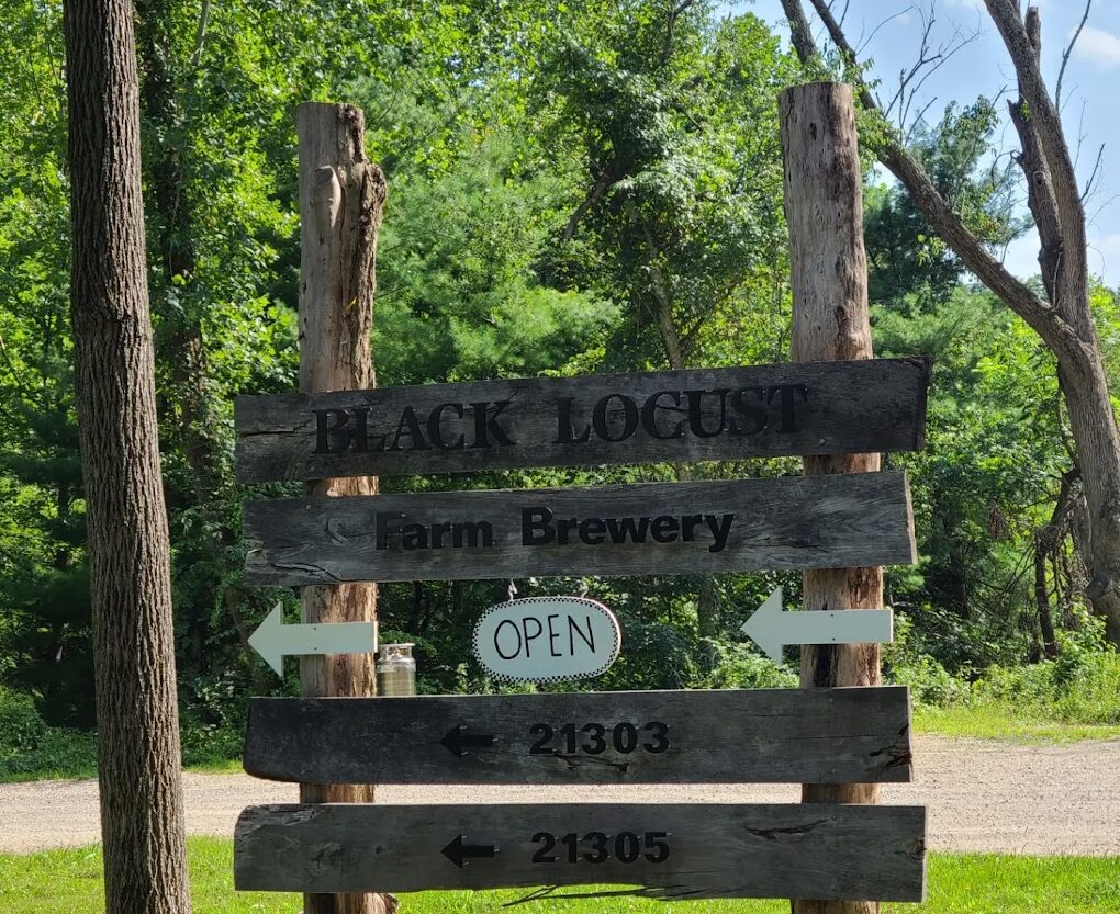 Wooden sign showing Black Locust Farm Brewery to the left.