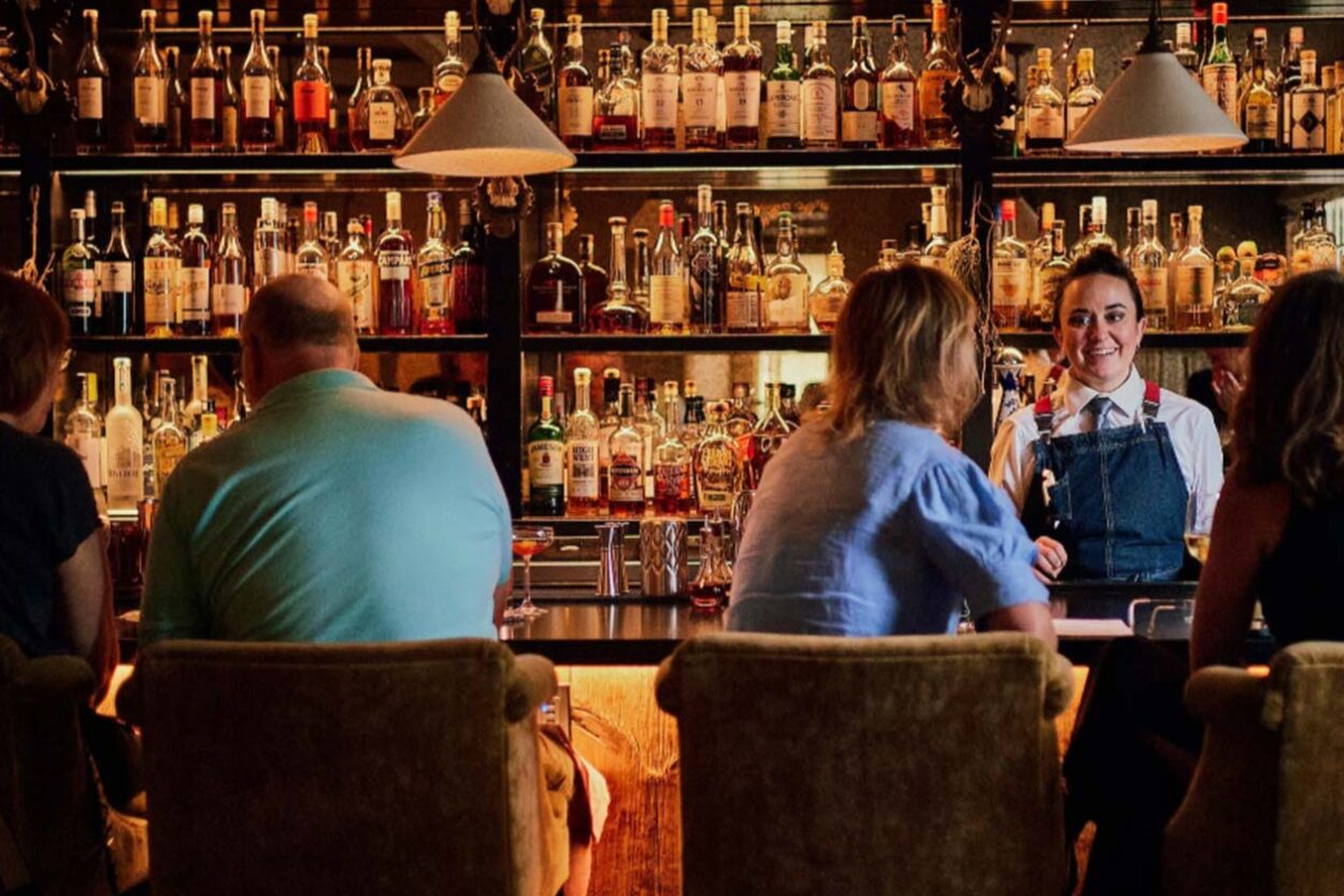 Man and woman sitting at a cozy, low lit bar