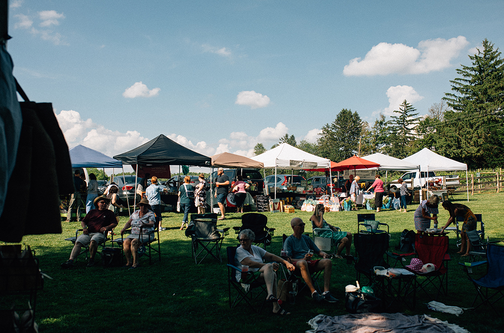 Group of people outside of Boordy Vineyards sitting in chairs and exploring the various markets set up under tents.